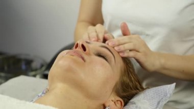 masör acupressure bir kadın yüzü üzerinde yapar. Çin alternatif tıp.