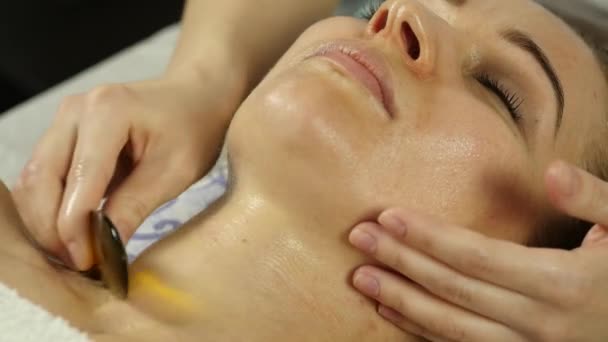 Estetista fa massaggio facciale per bella donna nel salone spa. rallentatore — Video Stock