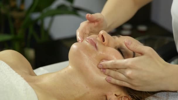 Masseur makes acupressure on a female face. Chinese alternative medicine. slow motion — Stock Video