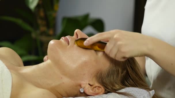 Masör acupressure bir kadın yüzü üzerinde yapar. Çin alternatif tıp. — Stok video