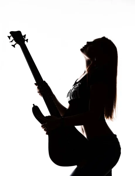 Silueta de mujer rock tocando en la guitarra eléctrica sobre un fondo blanco . — Foto de Stock