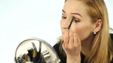 Günlük makyaj ve makyaj fırça önünde, ayna tutan güzel bir kadın. 4k