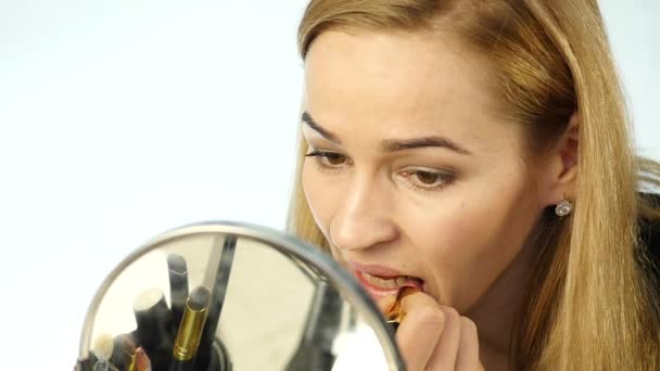 Hermosa mujer haciendo maquillaje todos los días y la celebración de cepillo de maquillaje delante del espejo. cámara lenta — Vídeos de Stock