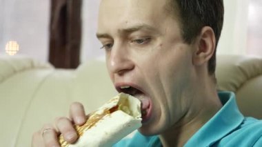 sıska adam büyük bir zevk ile fast food snack yiyor. abur cubur büyük iştahla çiğneme adam. ağır çekim