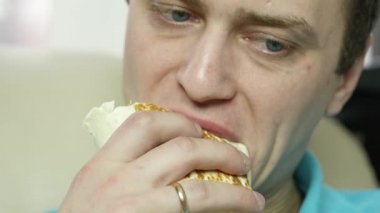sıska adam büyük bir zevk ile fast food snack yiyor. abur cubur büyük iştahla çiğneme adam. ağır çekim