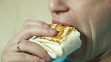 sıska adam büyük bir zevk ile fast food snack yiyor. abur cubur büyük iştahla çiğneme adam. ağır çekim