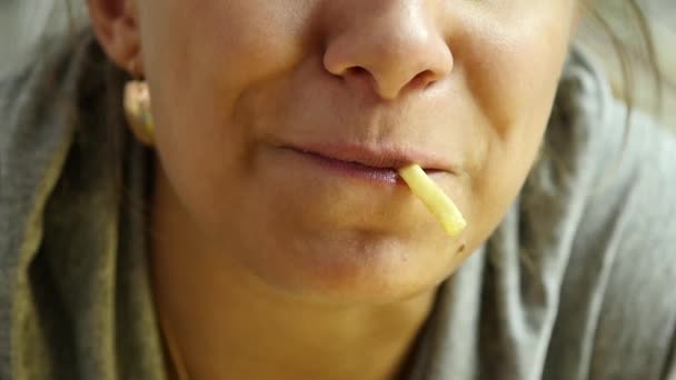 Mulher comendo junk food com grande prazer. A rapariga come batatas fritas. câmara lenta — Vídeo de Stock