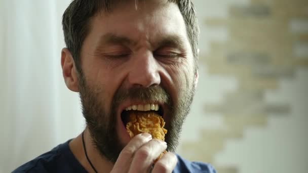 남자는 치킨 너 겟, 패스트 푸드, 탄산 음료와 함께 날개를 먹는다. 매우 정크 식품입니다. 슬로우 모션 — 비디오