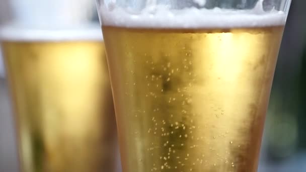 Холодное светлое пиво в стакане с каплями воды. пузырьки пива, замедленная съемка — стоковое видео