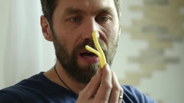 Homem barbudo comendo junk food com grande prazer. Ele come batatas fritas. câmara lenta — Vídeo de Stock