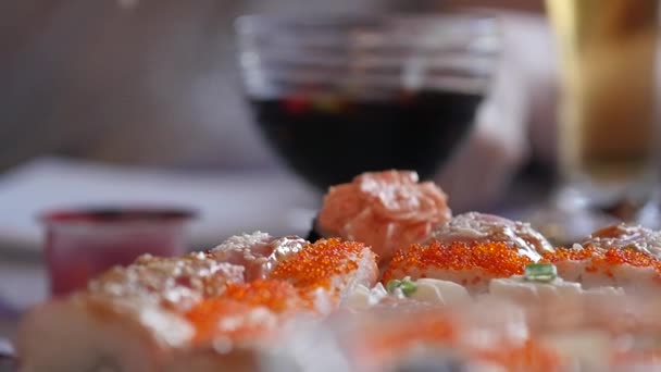 Eat sushi w domu używa pałeczki. Kuchnia Japońska, sushi rolls zwolnionym tempie — Wideo stockowe