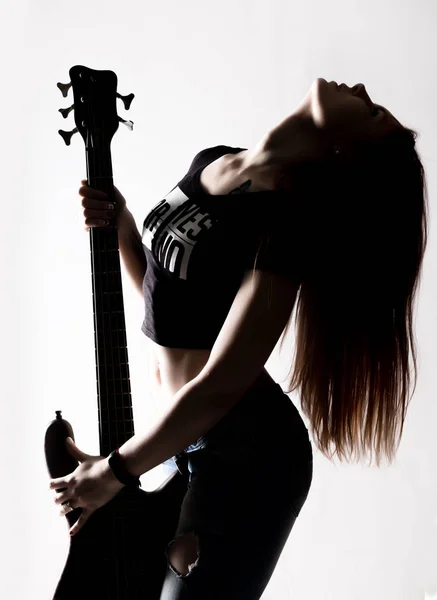 Silhouet van de vrouw van de rots spelen op de elektrische gitaar op een witte achtergrond. — Stockfoto