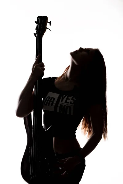 Silueta de mujer rock tocando en la guitarra eléctrica sobre un fondo blanco . — Foto de Stock