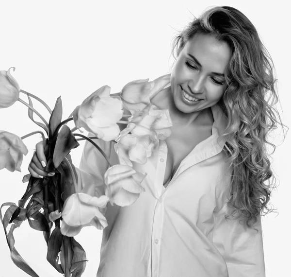 Beautiful curly girl with spring flowers tulips on a white background. black and white — Stock Photo, Image