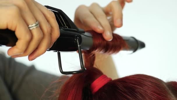 Професійний перукар робить завитки, використовує скручування стрижня. повільний рух — стокове відео