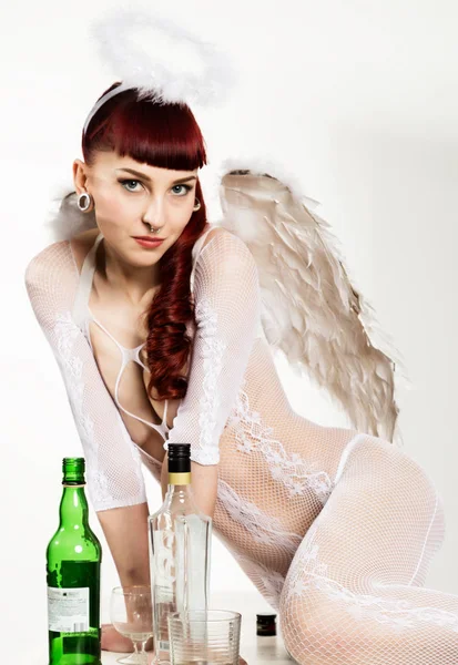 Roodharige meisje in Angel pak drinkt alcohol. Fallen Angel — Stockfoto