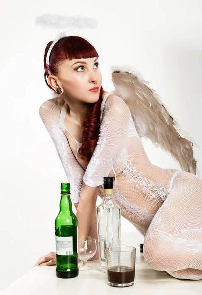 Roodharige meisje in Angel pak drinkt alcohol. Fallen Angel — Stockfoto