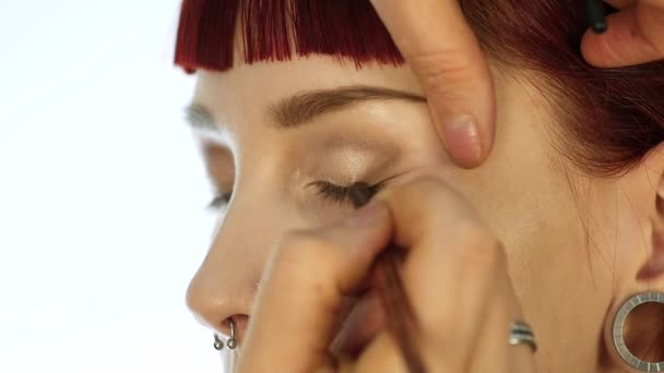 Mulher maquiagem olho aplicando pó sombra. Stylist está fazendo maquiagem para a fêmea por eyeliner — Vídeo de Stock