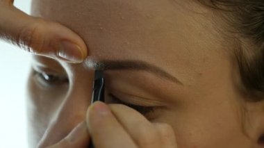 Göz makyaj kadın göz farı toz uygulamak. Stilist yapmak için erkek eyeliner tarafından yapıyor