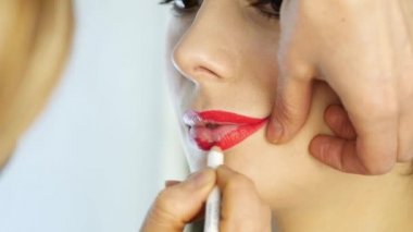 Profesyonel makyaj sanatçısı modeli dudaklarından kontur uygulamak. moda endüstrisi kozmetik