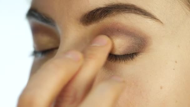 Makeupartist gäller en corrector under ögonen, smink för vacker kvinna i skönhetssalong — Stockvideo