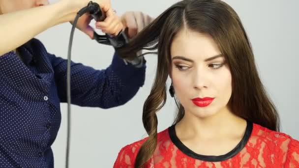 Professional hairdresser make curls, uses curling rod. fashion industry cosmetics. — Stock Video