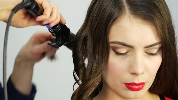 Professional hairdresser make curls, uses curling rod. fashion industry cosmetics. — Stock Video