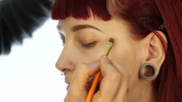Mulher maquiagem olho aplicando pó sombra. Stylist está fazendo maquiagem para a fêmea por eyeliner — Vídeo de Stock