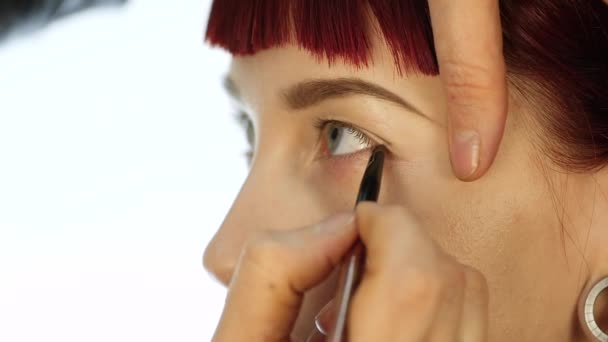 Mulher maquiagem olho aplicando pó sombra. Stylist está fazendo maquiagem para a fêmea por eyeliner — Vídeo de Stock