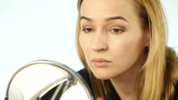 Hermosa mujer haciendo maquillaje todos los días y la celebración de cepillo de maquillaje delante del espejo. cámara lenta — Vídeo de stock