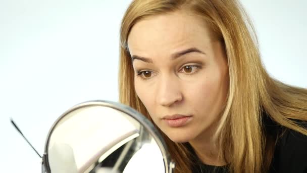 Hermosa mujer rubia haciendo maquillaje diario delante del espejo, dibuja las cejas con un cepillo pequeño. cámara lenta — Vídeos de Stock