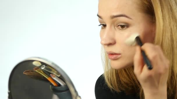 Mulher bonita fazendo maquiagem todos os dias e segurando escova de maquiagem na frente do espelho. câmara lenta — Vídeo de Stock