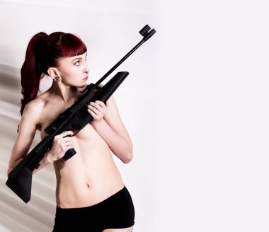Güzel seksi redhead pnömatik'ın hafif bir arka plan üzerinde elinde. metniniz için boş alan