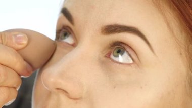 Kadın profesyonel makyaj sanatçısı modeli yüze krem temel astar uygulamak. ağır çekim