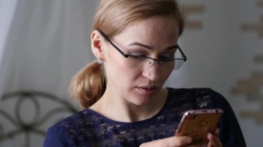 Sarışın işkadını bardaklarda smartphone cep telefonu ile bir şey kontrol. ağır çekim