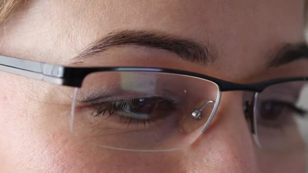 Gros plan oeil de femme brune dans des lunettes. Femme utilisant un smartphone. 4K — Video