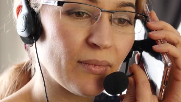 Una mujer de negocios hablando con un auricular en una oficina. servicio al cliente profesional. 4K — Vídeos de Stock