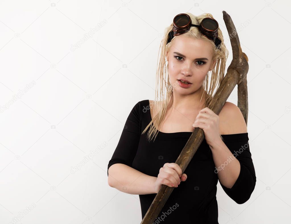 Beautiful sexy worker with a pickaxe. Seductive and beautiful woman miner on a light background