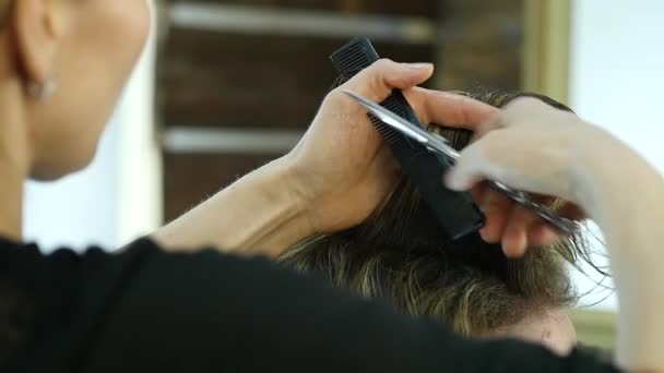 Barberos manos utiliza tijeras para dar forma a los hombres cabello en un salón de belleza. cámara lenta — Vídeos de Stock