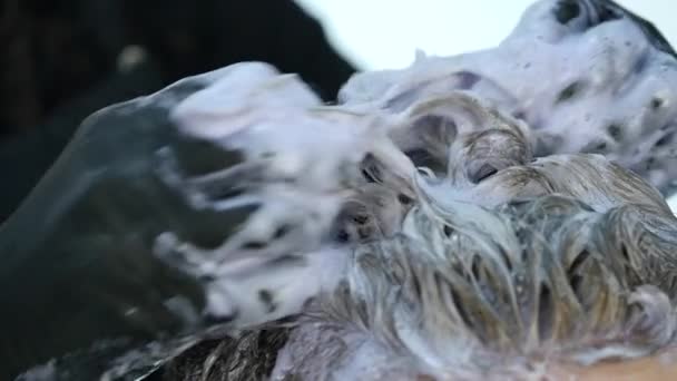 Перукар робить підсвічування волосся, фарбування волосся для чоловічого клієнта. повільний рух — стокове відео