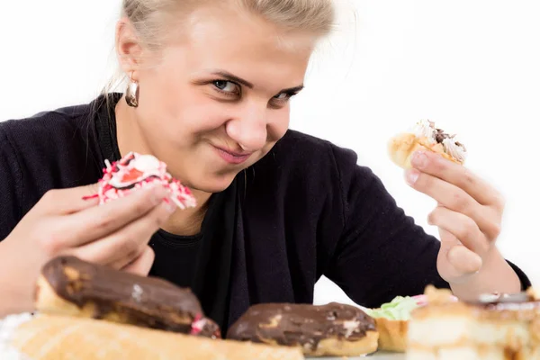 Mujer joven comiendo magdalenas con placer después de una dieta —  Fotos de Stock