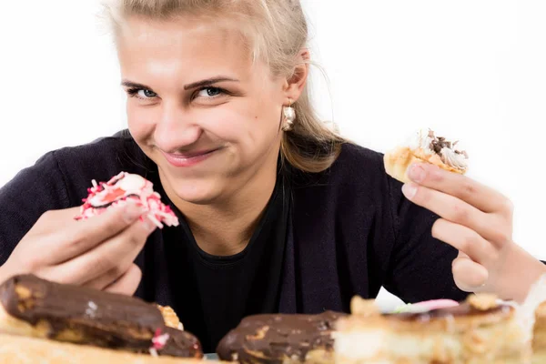 Mujer joven comiendo magdalenas con placer después de una dieta —  Fotos de Stock