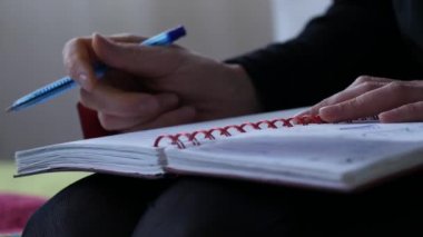 Üzgün genç kız öğrenci bir yatakta otururken günlüğüne yazar. ergen deneyimleri. 4k