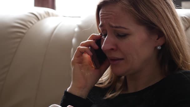 Mladá žena se cítí smutný a pláče při mluvení s někým na smartphone. Zpomalený pohyb — Stock video