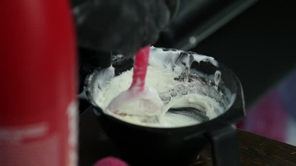 Coiffeur mélangeant la teinture capillaire dans un bol dans un salon de coiffure. préparation de teinture capillaire. 4K — Video