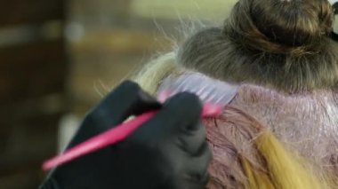 Kuaför Güzellik Salonu bir genç için boya saç modeli, yapar. Saç boya kaplı. 4k