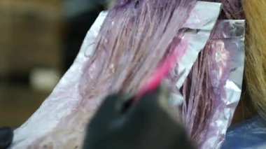 Kuaför Güzellik Salonu bir genç için boya saç modeli, yapar. Saç boya kaplı. 4k