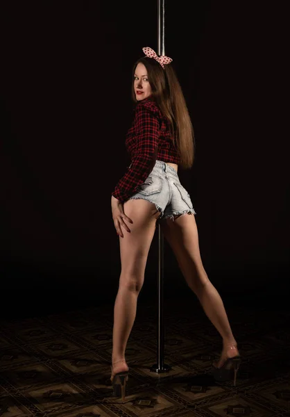 Vackra go-go dansare i denim shorts och rutig skjorta i nattklubben. Pole Dance pin-up girl — Stockfoto