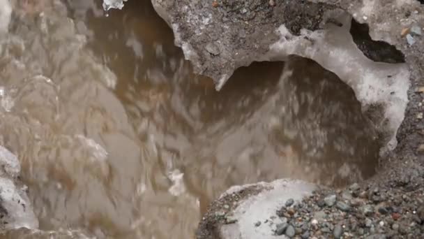 Riviertje stroomt door het ijs in het voorjaar. Slow motion — Stockvideo