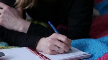 bir yatakta yatarken ve günlüğüne yazma dalgın ev hanımı. 4k